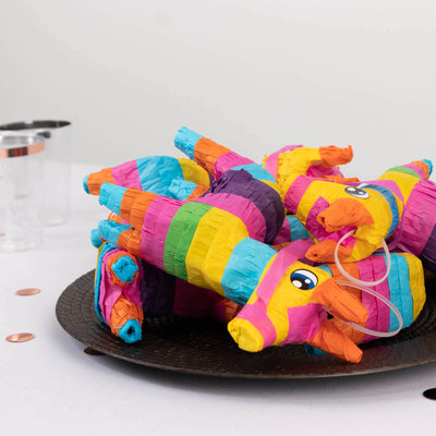 Colorful unicorn piñatas stacked on a plate for a festive celebration.