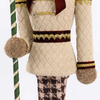 Handmade festive doll in knit sweater holding a striped staff

