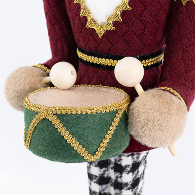 Toy soldier nutcracker holding a green drum with drumsticks