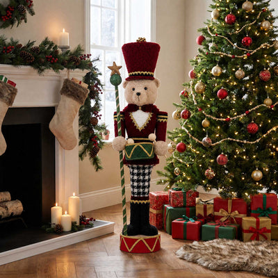 Christmas living room with decorated tree, nutcracker teddy bear, fireplace and gifts