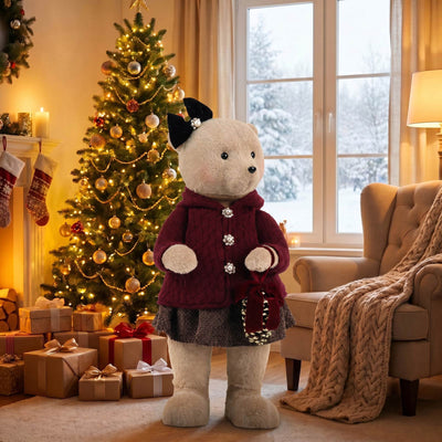 Plush bear in winter outfit beside decorated Christmas tree in cozy living room