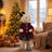 Plush bear in winter outfit beside decorated Christmas tree in cozy living room