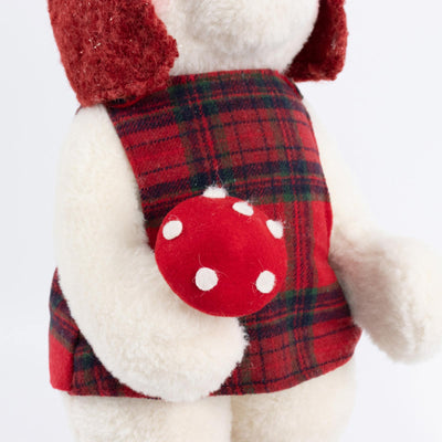 Plush teddy bear in red plaid dress holding a polka dot heart ornament