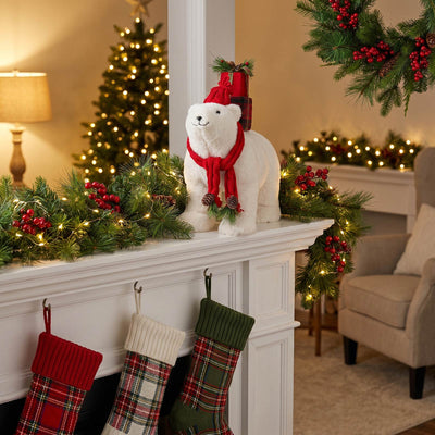 Cozy Christmas mantel with polar bear decor, garland, stockings, and twinkling lights