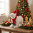 Christmas polar bear plush with gift, red scarf, and decorated tree backdrop