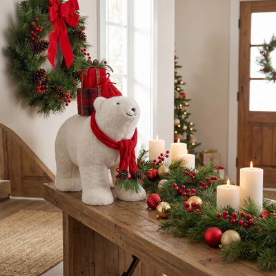Christmas table decor with polar bear figurine, wreath, candles, and garland
