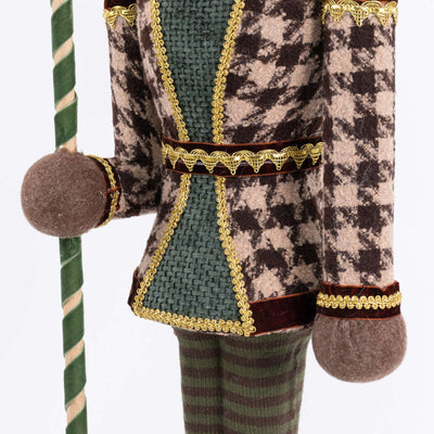 Decorative nutcracker figurine with green staff and ornate velvet outfit