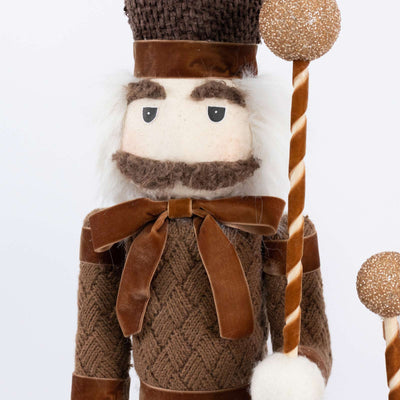 Nutcracker Christmas doll in brown knit outfit with candy cane staff