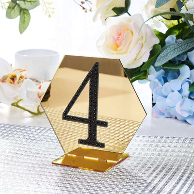 Gold hexagon table number 4 sign with rhinestones on a decorative table setting.