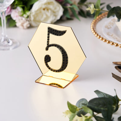 Gold hexagonal table number holder with black glitter number 5.