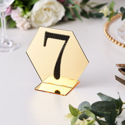 Gold hexagon table number 7 holder with mirrored finish and black embellishments.