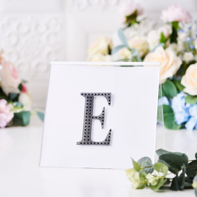 Decorative letter 'E' on a clear display with floral background