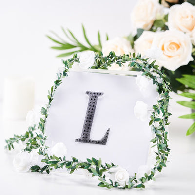 Decorative letter "L" with floral accents in a clear frame