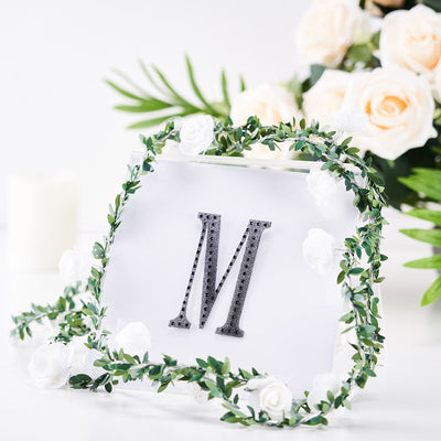 Decorative frame with letter "M" surrounded by floral accents