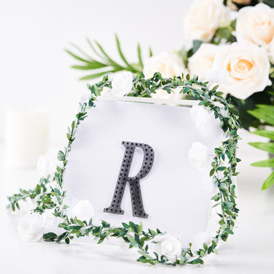 Decorative frame with letter "R" and floral accents