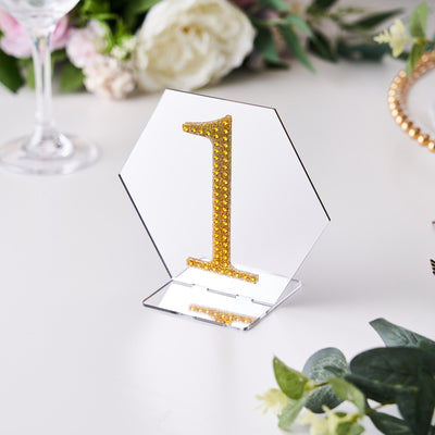Gold glitter number one table centerpiece on clear acrylic hexagon base.