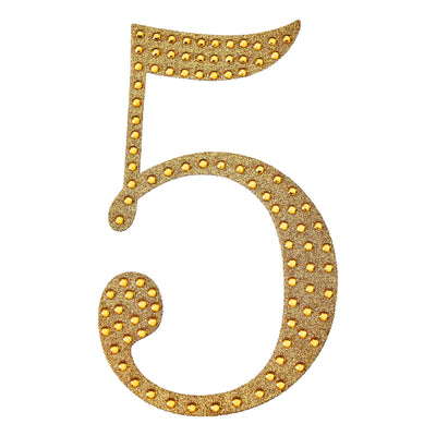 Glittery gold number 5 with lights on a plain background