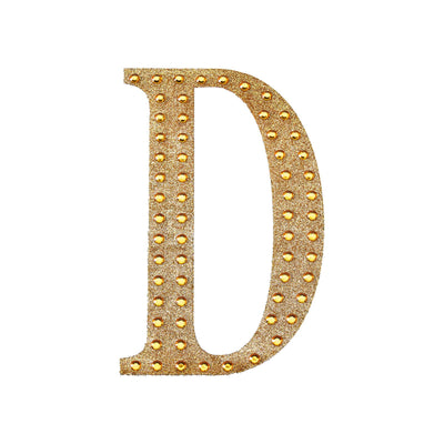 Gold glitter letter "D" with rhinestones on a plain background