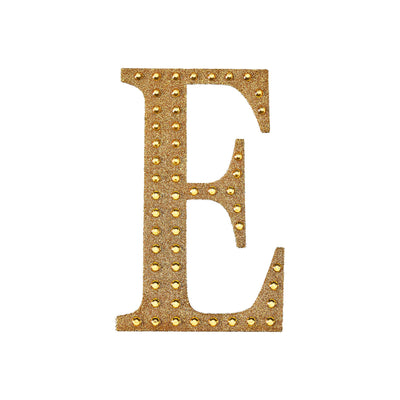 Gold studded letter "E" decorative accent on white background