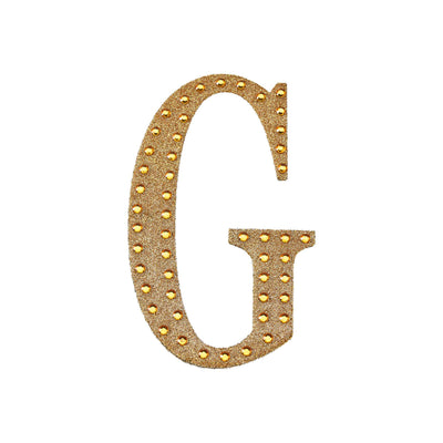 Gold marquee letter G with lights on a white background