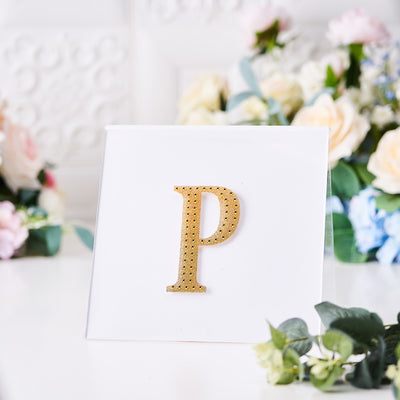 Gold rhinestone letter "P" on a white card with floral background.