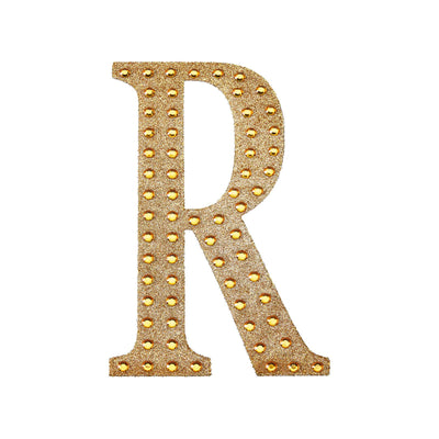 Gold letter "R" with studded design on a white background.