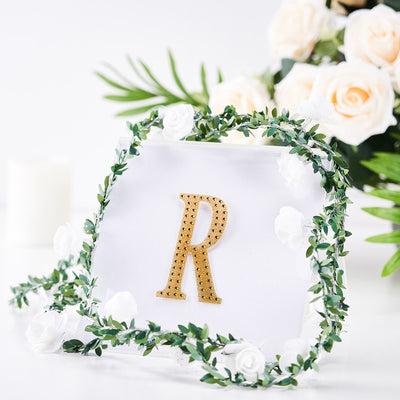 Gold letter "R" decorative initial with floral accents