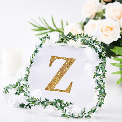 Gold letter Z with floral wreath decoration on a clear background.