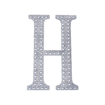 Silver rhinestone letter "H" on a plain background.