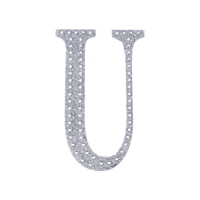 Silver rhinestone letter "U" on a plain background.