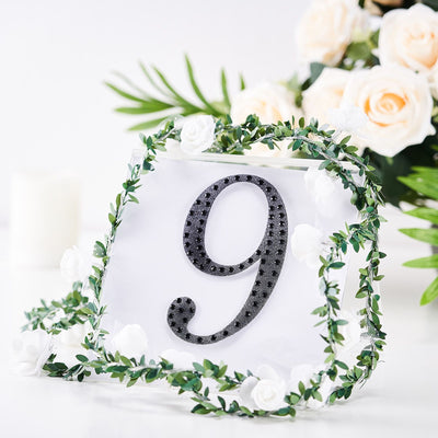 Decorative table number 9 with greenery and floral accents.