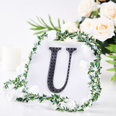 Black letter "U" with floral accents on a white background.