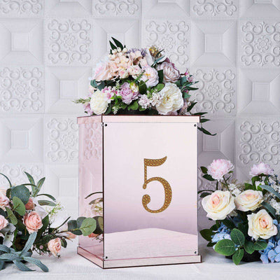 Decorative mirrored box with floral arrangement and gold number 5.