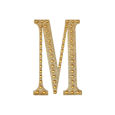 Gold marquee letter "M" with lights on a white background.