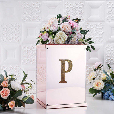 Rose gold flower box with decorative letter "P" and floral arrangement.