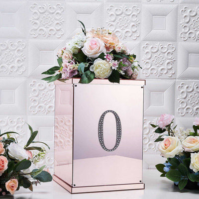Rose gold flower box with number "0" and floral arrangement on a textured background.