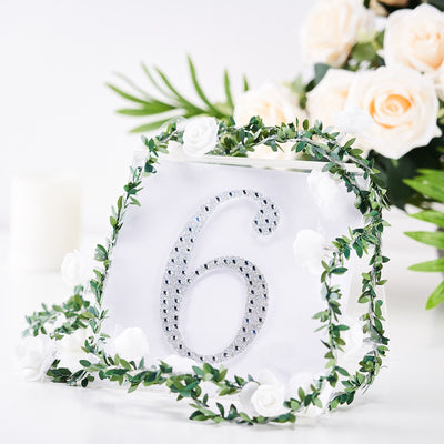 Table number 6 adorned with greenery and flowers for event decoration.