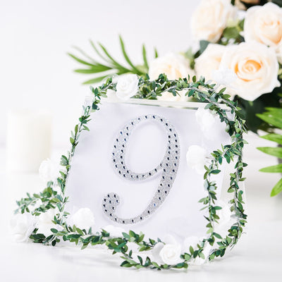 Decorative table number 9 with floral accents and greenery arrangement.