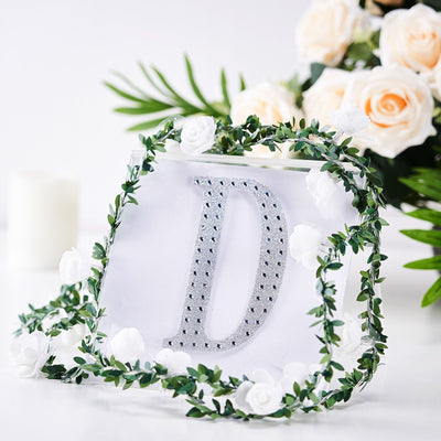 Clear acrylic letter "D" adorned with floral decorations.