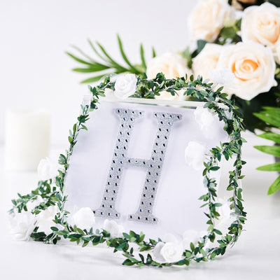 Decorative letter "H" with floral accents on a white background.