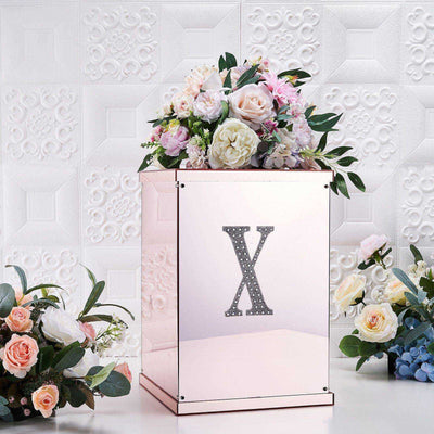 Decorative rose gold box with floral arrangement on a textured background.