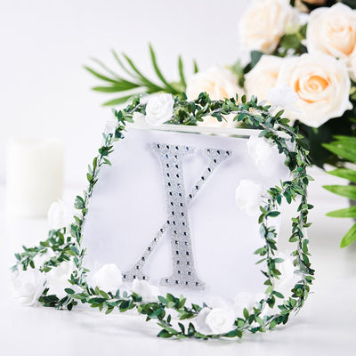 Decorative purse with rhinestone letter "X" surrounded by floral accents.