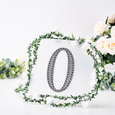 Decorative number "0" surrounded by floral garland on a plain backdrop.
