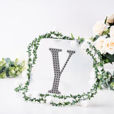 Decorative letter "Y" surrounded by flowers and greenery.