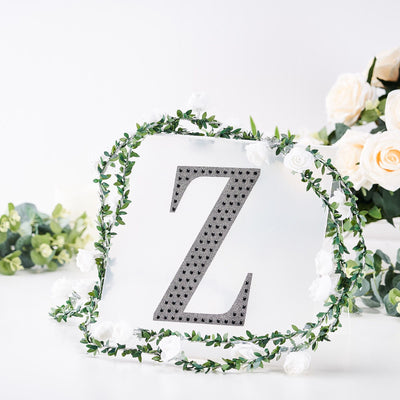 Decorative letter "Z" surrounded by floral garland on a white background.