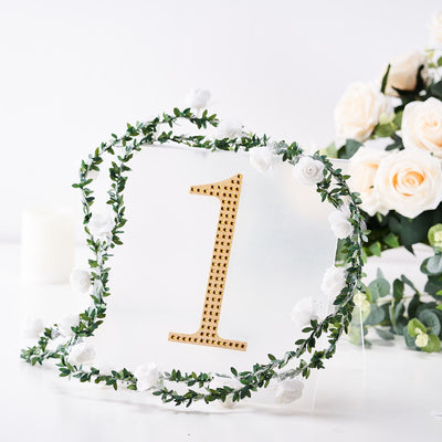 Gold number one sign surrounded by white flowers and greenery