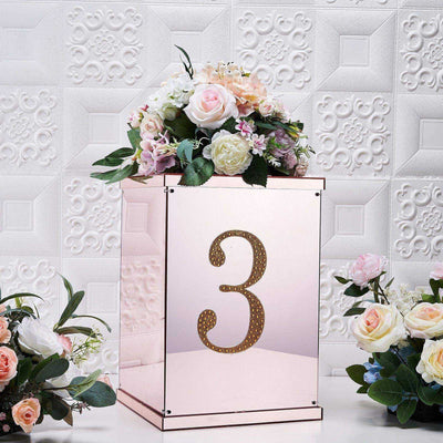 Rose gold table number display with floral arrangement and number 3.