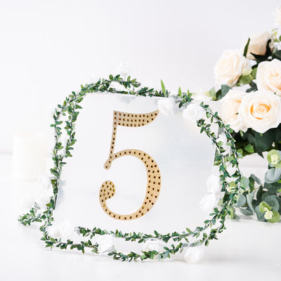 Gold number 5 table centerpiece with floral decoration.