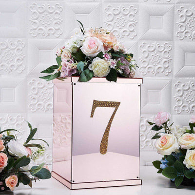 Rose gold table number holder with floral arrangement, featuring the number 7.