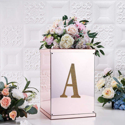 Floral arrangement in a decorative box with a gold letter 'A' on a textured background.